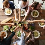 A vibrant group cheers over a delicious meal, showcasing friendship and togetherness.