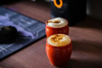 two orange cups sitting on top of a wooden table